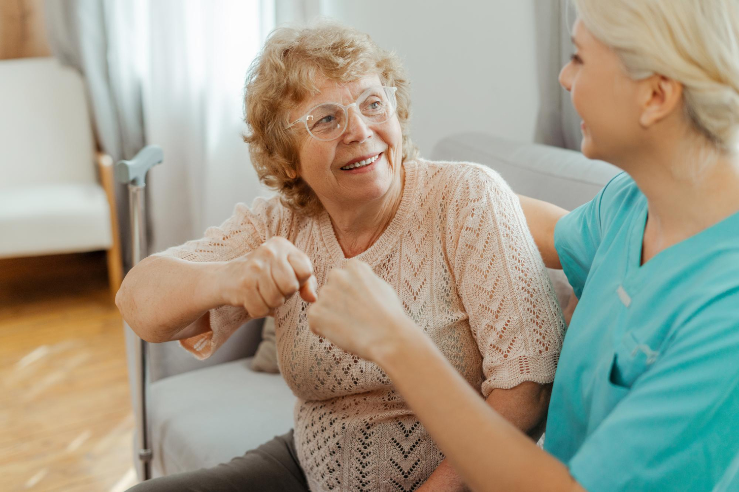 Caregiver helping elderly woman look at tablet